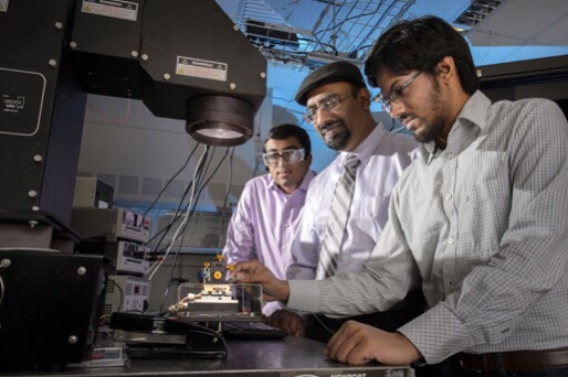 Doctoral student Aditya G. Baradwaj (at left), professor Muhammad A. Alam (center) and doctoral student Ryyan Khan, operate a solar simulator. They are members of a research team led by former doctoral student Biswajit Ray and also involving assistant professor Bryan Boudouris. The group is reporting new findings that contradict a fundamental assumption about the functioning of "organic" solar cells made of low-cost plastics. The findings suggest a new strategy for creating inexpensive solar technology. (Purdue University image/John Underwood) 