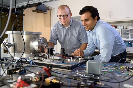 CAPTION Post-doctoral scholar Peter McMahon, left, and visiting researcher Alireza Marandi examine a prototype of a new type of light-based computer. CREDIT L.A. Cicero