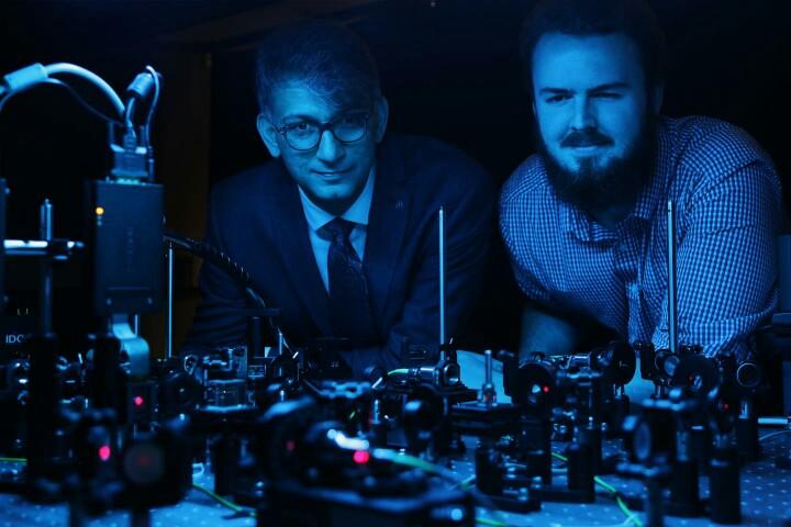  Professor Ebrahim Karimi, a member of uOttawa's Department of Physics and holder of the Canada Research Chair in Structured Light, and doctoral student Frédéric Bouchard observe the setup they used to clone the photons that transmit information, called qudits.