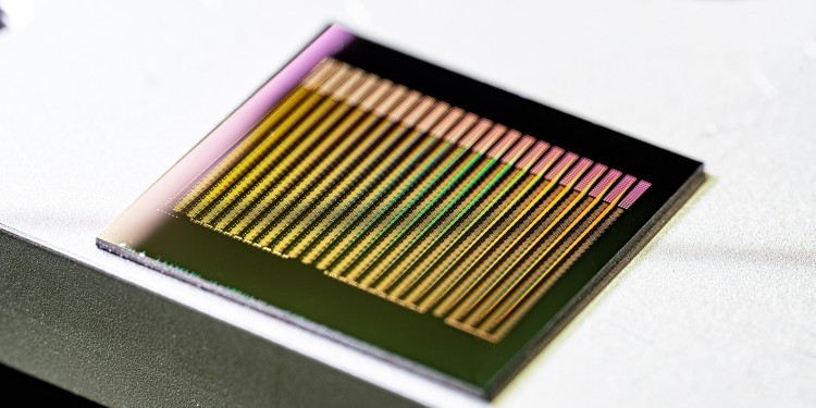The chip contains 8,400 functional artificial neurons made of waveguide-coupled phase-change material. The neural network was trained to differentiate between German and English texts based on vowel frequency. © Jonas Schütte / AG Pernice