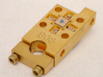 This NIST device, 1.5 by 3 centimeters in outer dimensions, is a prototype receiver for laser communications enabling much higher data rates than conventional systems. Superconducting detectors in the center of the small square chip register the timing and position of single particles of light.  By Verma and Tomlin/NIST