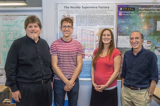 From left, Greg Aldering, Kyle Boone, Hannah Fakhouri and Saul Perlmutter of the Nearby Supernova Factory. Behind them is a poster of a supernova spectrum. Matching spectra among different supernovae can double the accuracy of distance measurements. (Photo by Roy Kaltschmidt/Berkeley Lab)