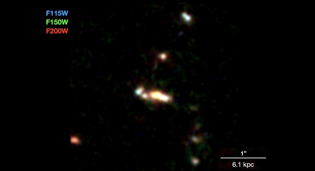 A group of small galaxies, seen almost 13 billion years back in time, likely in the process of forming a massive galaxy. The colors are composed from three different infrared colors. The white, horisontal bar shows the scale of approximately 20,000 lightyears. Credit: Shuowen Jin et al. (2023).