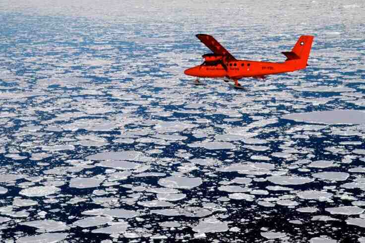 A BAS Twin Otter flies over Antarctic sea ice. A BAS Twin Otter flies over Antarctic sea ice.