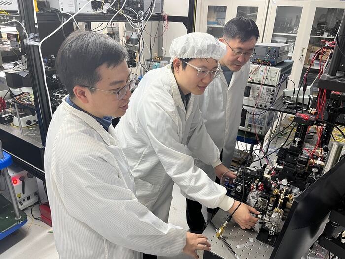 (from left) Researchers Haowen Shu, Zihan Tao and Xingjun Wang performing an experiment to test their microwave photonic filter. (from left) Researchers Haowen Shu, Zihan Tao and Xingjun Wang performing an experiment to test their microwave photonic filter.
