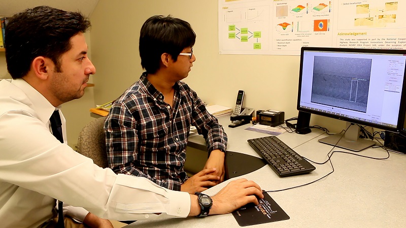 Mohammad R. Jahanshahi, left, an assistant professor in Purdue’s Lyles School of Civil Engineering, and doctoral student Fu-Chen Chen review results using the new system. (Purdue University image/Erin Easterling) Mohammad R. Jahanshahi, left, an assistant professor in Purdue’s Lyles School of Civil Engineering, and doctoral student Fu-Chen Chen review results using the new system. (Purdue University image/Erin Easterling)
