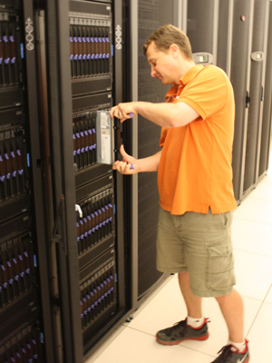 Chad Dougherty, research programmer in the Parallel Data Lab, inserts a blade computer salvaged from the Los Alamos National Laboratory into a rack of the new Narwhal computing cluster. Chad Dougherty, research programmer in the Parallel Data Lab, inserts a blade computer salvaged from the Los Alamos National Laboratory into a rack of the new Narwhal computing cluster.